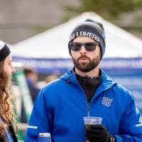 Two alumni enjoy drinks at the tailgate
